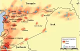 Cette image est une carte géographique représentant une région du Moyen-Orient, plus précisément la Syrie et ses environs. On voit différentes villes et régions importantes comme Alep, Homs, Damas, et Raqqa. La carte utilise des zones colorées pour indiquer des itinéraires d'émigration, avec des nuances de rouge signalant des niveaux d'émigration élevés ou faibles. Des symboles, comme des carrés bleus, semblent indiquer des camps de réfugiés à divers endroits. La Turquie et l'Irak sont également mentionnés sur les bords de la carte, indiquant les frontières régionales.