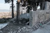 Ruines avec des murs érodés, arbres et débris au sol. Atmosphère désolée.