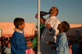L'instituteur du camp de Smara aide ses élèves à hisser le drapeau de la RASD
