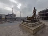 Dietro la statua in omaggio agli sgomberatori, le rovine della città vecchia
