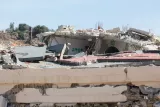 Ruines d'un bâtiment effondré, débris éparpillés sous un ciel bleu.