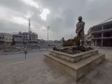 Derrière la statue en hommage aux déblayeurs, les ruines de la vieille ville