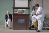 Sociabilités autour d'un artisan horloger devant un supermarché d'Al-Sadd