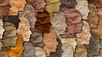 تظهر الصورة مجموعة من الوجوه البشرية المصنوعة من ورق ملتوي بألوان مختلفة تتراوح بين درجات البيج والبني. تعكس هذه الألوان تنوع البشرة، حيث يتم ترتيب الوجوه بشكل متداخل، مما يخلق تأثيرًا فنيًا مميزًا. تبرز الأشكال والظلال الملتوية، مما يعطي انطباعًا عن الحركة والتنوع الثقافي.