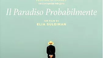 L'immagine sembra rappresentare un poster di un film intitolato "It Must Be Heaven", diretto da Elia Suleiman. In primo piano, c'è una figura umana di spalle, vestita con abiti leggeri e un cappello, che si trova su una scogliera e osserva l'orizzonte. Sullo sfondo, si vede un cielo sereno e un mare blu, creando un'atmosfera di tranquillità e contemplazione. Il titolo del film e il nome del regista sono scritti in caratteri chiari, dando risalto alla scena.