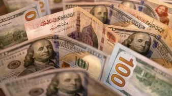 L'image montre un assortiment de billets de banque, probablement des dollars américains. On peut voir plusieurs billets de 100 dollars, avec des illustrations de Benjamin Franklin, ainsi que d'autres détails de la conception des billets. Les billets sont disposés de manière à créer une sorte de fan, mettant en évidence les différentes couleurs et motifs.