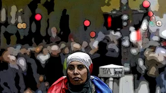تصویر یک زن را نشان می‌دهد که به سمت دوربین نگاه می‌کند و روی دوش او یک پرچم، احتمالاً پرچم فرانسه، قرار دارد. او به نظر می‌رسد در یک خیابان شلوغ ایستاده است و جمعیتی در پس‌زمینه دیده می‌شود. نقاط نورانی و رنگی در پس‌زمینه به تصویر حس شهری و پویایی می‌دهند. خانم در تصویر حجاب بر سر دارد و احساس جدیت و تمرکز را منتقل می‌کند.