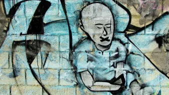 L'image présente un graffitti sur un mur. On y voit le dessin d'une figure humaine stylisée, sans cheveux, avec un visage exprimant le silence, probablement pour symboliser l'oppression ou le manque de voix. Ses lèvres sont représentées comme étant scellées. Le fond est composé de couleurs bleu et gris, avec des formes abstraites qui ajoutent de la texture à l'œuvre. L'ensemble dégage une ambiance à la fois poignante et réfléchie.