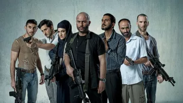 L'image montre un groupe de sept personnes armées, se tenant debout sur un fond gris. Ils ont des expressions déterminées et semblent en position de confrontation. Certains d'entre eux tiennent des armes à feu, tandis qu'une femme porte un hijab et se tient au milieu du groupe. Les hommes sont vêtus de vêtements variés, allant de casual à militaire. L'atmosphère est intense et pourrait suggérer un contexte d'action ou de tension.