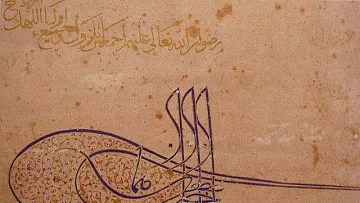 L'image présente un travail calligraphique élaboré, probablement en arabe, qui combine à la fois des mots et des formes artistiques. On observe des lignes fluides et des motifs détaillés, créant une composition harmonieuse. Le texte semble exprimer un message spirituel ou religieux, mettant en valeur la beauté de la langue arabe à travers l'art de la calligraphie. Les couleurs sont principalement des nuances de brun et de doré, ce qui donne une impression de chaleur et d'élégance.