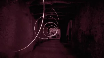 L'image présente un couloir sombre et étroit, avec des murs en pierre, qui semble s'étendre à l'infini. Des spirales lumineuses de couleur rose flottent dans l'air, créant une atmosphère mystérieuse et surréaliste. La lumière des spirales se détache sur le fond sombre, ajoutant une dynamique captivante à la composition. Le sol est en pierre, et la structure du plafond est visible, renforçant le sentiment d'un espace ancien ou abandonné.