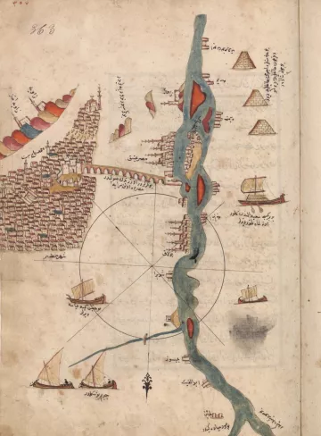 L'image représente une ancienne carte maritime ou géographique. On y voit une portion de la ville avec des bâtiments, ainsi que des pyramides. Un fleuve est illustré au centre, avec des bateaux naviguant sur ses eaux. La carte contient des annotations en arabe et des éléments décoratifs, comme des motifs colorés. L'ensemble semble avoir été réalisé à la main, avec un style artistique qui reflète les pratiques cartographiques de l'époque.